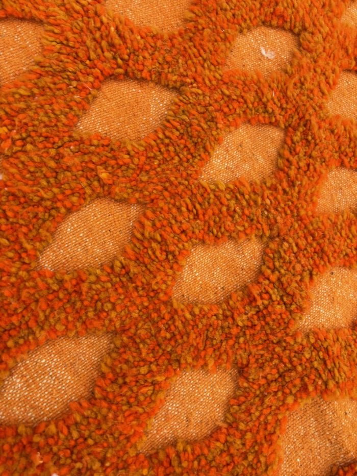 Détail du tissage artisanal d'un tapis berbère moderne en laine naturelle.